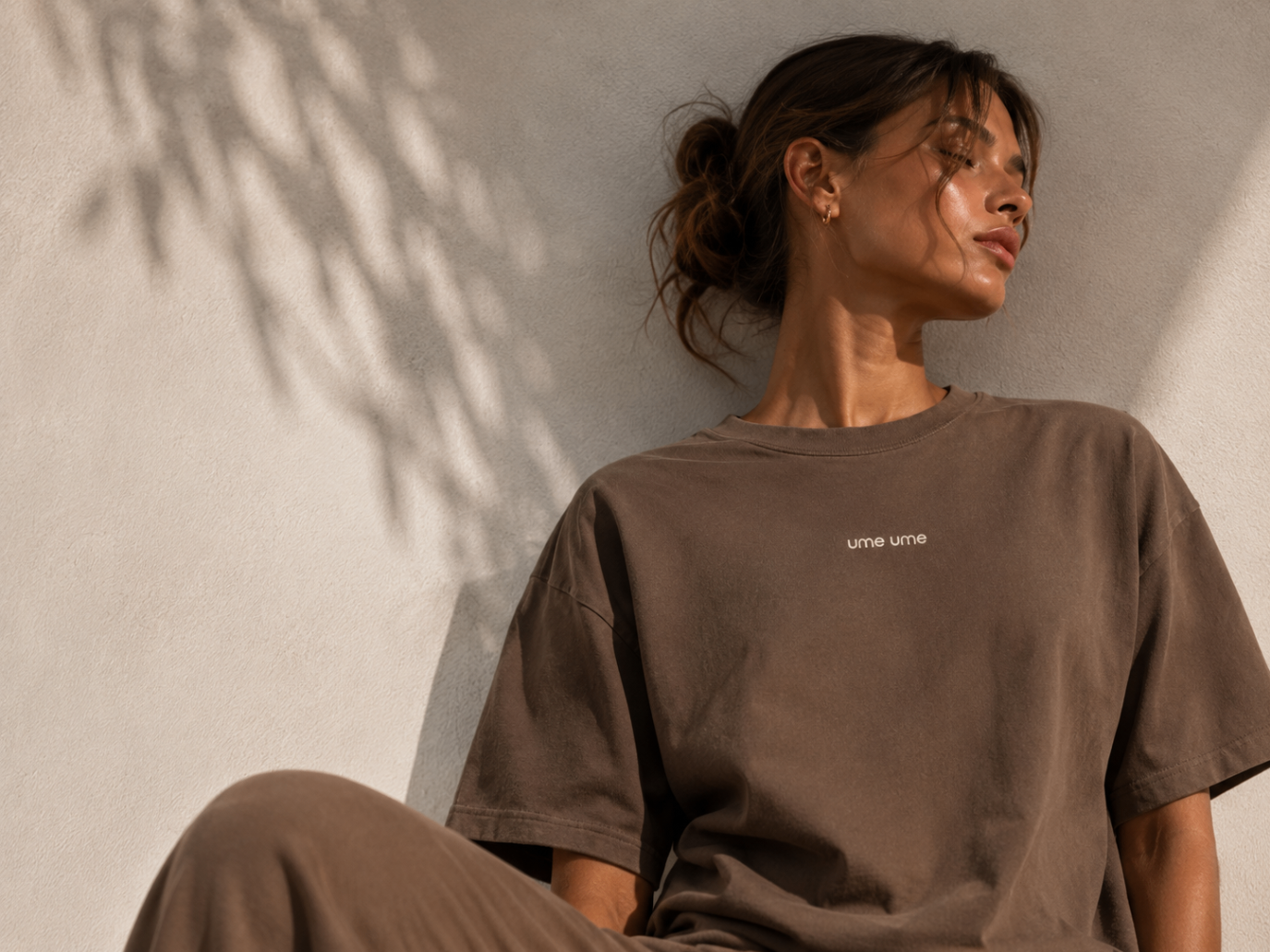 Editorial lifestyle image of a woman in a brown ume ume tee
